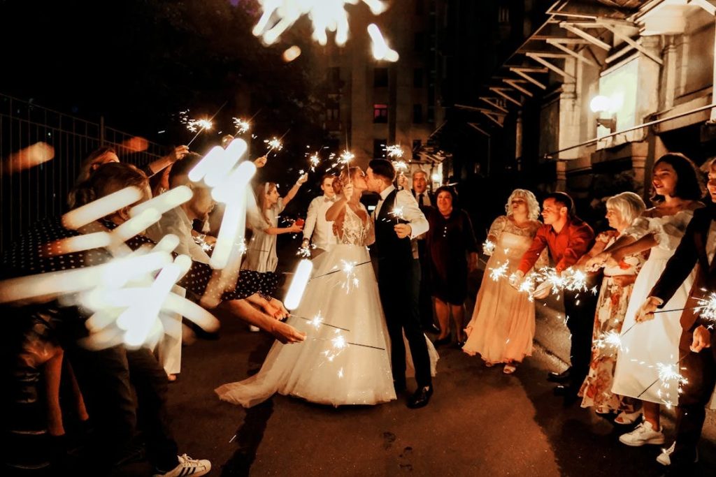 wedding couple walking out of a wedding venue as guests hold sparklers